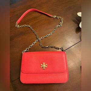 This is a Tory Burch Kira pebbled leather crossbody bag in a vibrant red color.